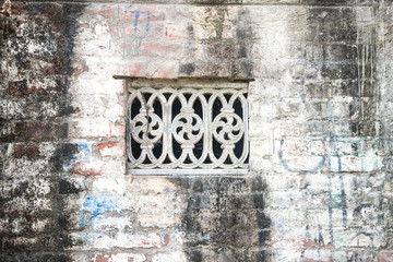 Beautiful vintage ancient old carved window with glass with a forged frame arches and patterns. The background.