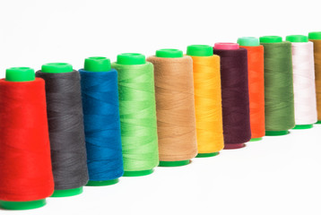 Colorful bobbin thread isolated on white background.