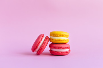 Three tasty french macarons on pink background.