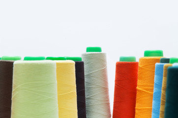 Colorful bobbin thread isolated on white background.