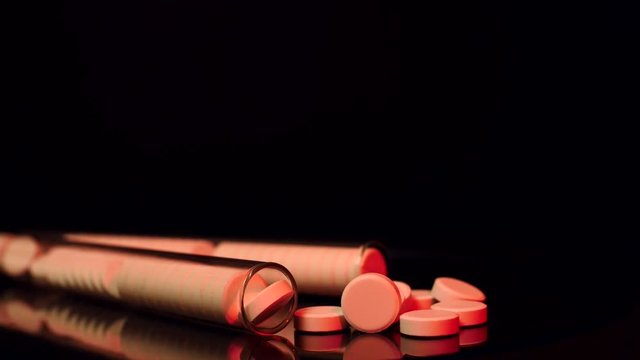 Generic drugs on table top, camera moves slowly accross spilled pills and into the bottle.
