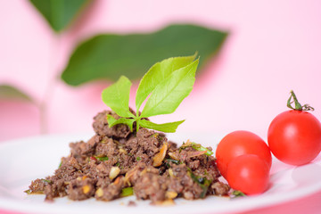 Spicy minced pork (Larb Moo) with fresh tomato, traditional northern Thai food
