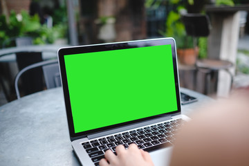 A man is working using laptop at coffee shop, blank green screen for background.