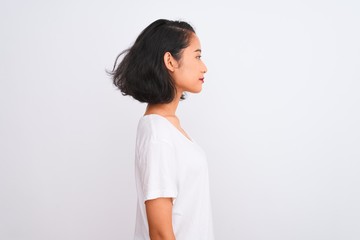 Young chinese woman wearing casual t-shirt standing over isolated white background looking to side,...