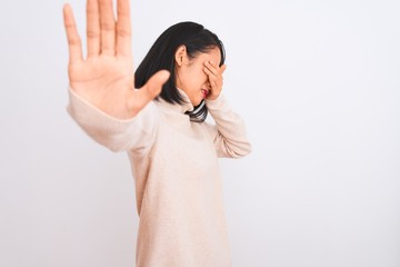 Young chinese woman wearing turtleneck sweater standing over isolated white background covering eyes with hands and doing stop gesture with sad and fear expression. Embarrassed and negative concept.