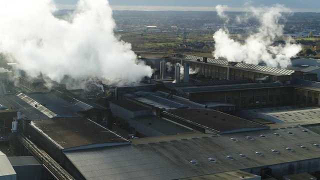 Wide aerial view of steam billowing from a UK paper mill. Establishing shot of UK Victorian infrastructure.