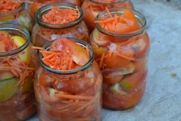 Fototapeta na wymiar Village, cottage, farm, cellar. Tasty and healthy. Preservation. Blanks for the winter. Marinated tomatoes. Grated carrot, Red and yellow tomatoes in jars