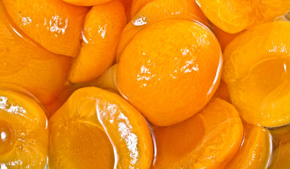 Canned peach halves in syrup. Background.