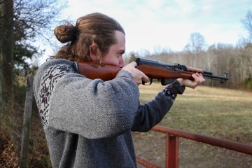 Young Generation Y or Millennial Male aged 20-30 demonstrating how to safely use a SKS firearm at an open shooting range