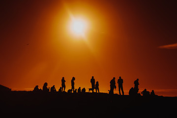 Fototapeta na wymiar Silhouettes Of People Standing Near Cliff