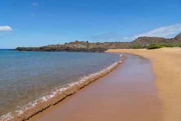 Waves on the volcanic Golden Beach on the island of Santiago, Galapagos Islands.