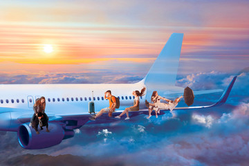 Tourists fly on vacation and sitting on wing of  jet passenger  airplane at evening sunset