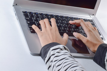 Fototapeta na wymiar Female hands typing on laptop keyboard at the office. Closeup. 