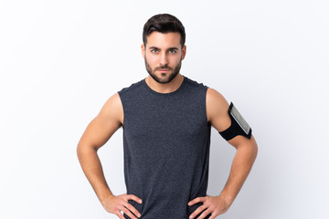Young sport handsome man with beard over isolated white background posing with arms at hip