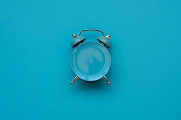 Time to eat. Empty plate as clock on blue background. Mock-up. Top view. Flat lay. Weight loss and...