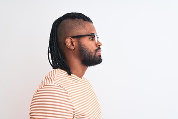 Obraz premium African american man wearing striped t-shirt and glasses over isolated white background looking to side, relax profile pose with natural face with confident smile.