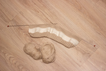 Brown knitting on light background .Knitting needles and skeins of wool, hand knitting. Selective...