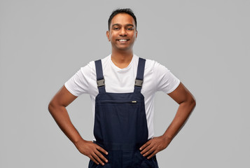 Fototapeta premium profession, construction and building - happy smiling indian worker or builder over grey background