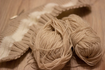 Brown knitting on light background .Knitting needles and skeins of wool, hand knitting. Selective...