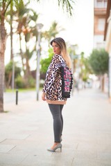Obraz premium Young beautiful girl wearing animal print cardigan walking at the town street