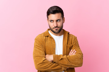 Young handsome man with beard wearing a corduroy jacket over pink background thinking an idea