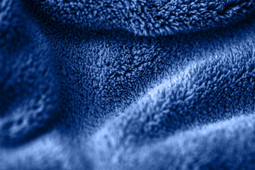 Blue delicate soft background of fur plush smooth fabric. Texture of fleecy blanket textile