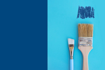 Two paint brushes on classic blue background with copy space.