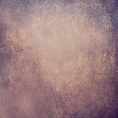 A rough uneven wall with a scratched purple surface.Texture or background