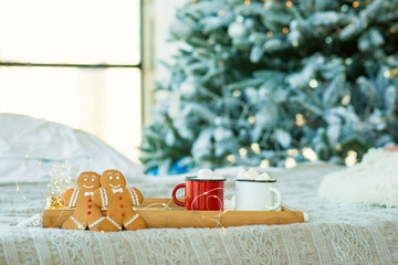 christmas gingerbread men, mugs with cocoa and christmas tree