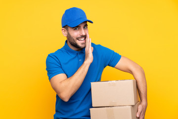 Delivery man over isolated yellow background whispering something