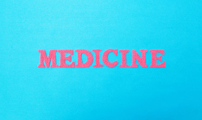 Word medicine made of red letters on a blue background. The concept of varieties of medicine military and space medicine