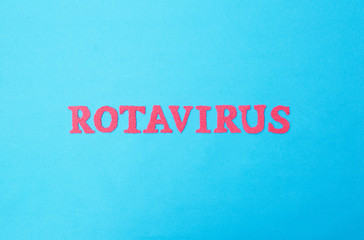 Word rotavirus made of red letters on a blue background. The concept of rotavirus infection in children and adults, intestinal flu.