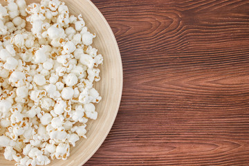 Pop corn snack in bowl, on the wooden table. Top view, banner mockup for cinema and tv movie
