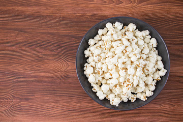 Pop corn snack in bowl, on the wooden table. Top view, banner mockup for cinema and tv movie
