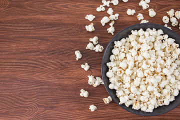 Pop corn snack in bowl, on the wooden table. Top view, banner mockup for cinema and tv movie