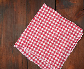 white red checkered kitchen towel on a brown wooden background