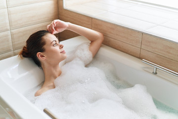 Obraz na płótnie Canvas young woman relaxing in bubble bath