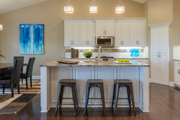 Modern kitchen with white cabinets and stainless steel appliances 