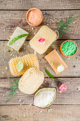 Bodycare organic cosmetics. Spa setting with basic hygiene treatment - sea salt, washcloth and natural handmade soap, and bath stuff ready for use. Zero waste bath care concept. Wooden background