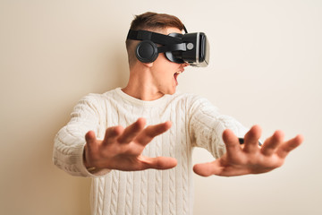 Young handsome teenager boy playing virtual reality game using goggles