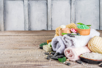 Bodycare organic cosmetics. Spa setting with basic hygiene treatment - sea salt, washcloth and natural handmade soap, and bath stuff ready for use. Zero waste bath care concept. Wooden background