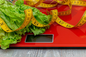 digital electronic scale with measuring tape, lettuce. diet, slimming concept.