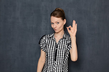 Portrait of young woman showing okay or zero gesture