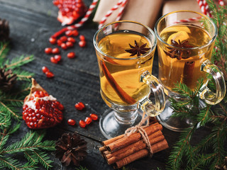 Traditional Christmas hot drink on the table with Christmas tree branches and gifts