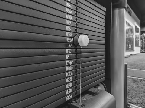 Black and white image of weight options for body building and weight lifting in a modern and well equipped gym for weight loss and getting physical