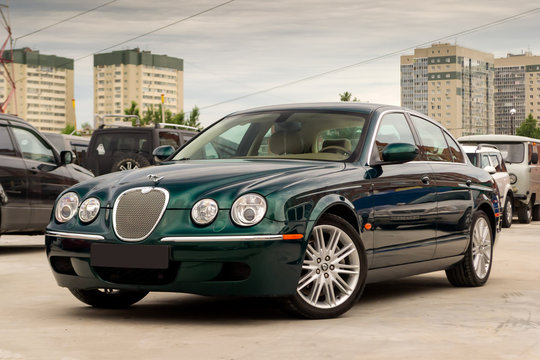 Novosibirsk, Russia - 06.28.2018: Brightly green Jaguar S-type 2007 front view with light beige interior in excellent condition in a parking space among other cars