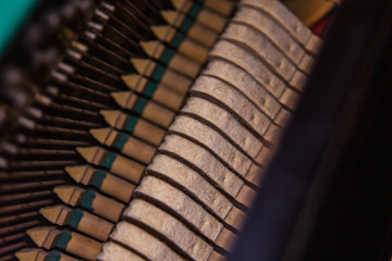 Close up of old broken dusty piano from the inside. Hammers in abandoned piano striking strings. Music playing from the ancient ruined piano. Gavel of the string open mechanism.
