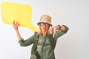 Senior hiker woman wearing canteen holding speech bubble over isolated white background with angry face, negative sign showing dislike with thumbs down, rejection concept