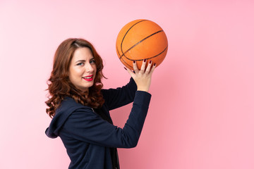 Young Russian woman over isolated pink background with ball of basketball