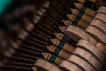 Close up of old broken dusty piano from the inside. Hammers in abandoned piano striking strings....